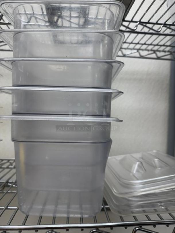 Set of five Vigor stainless steel 1/6 x 6 pans with lids, stacked on a wire shelf. Uniform design, good condition.