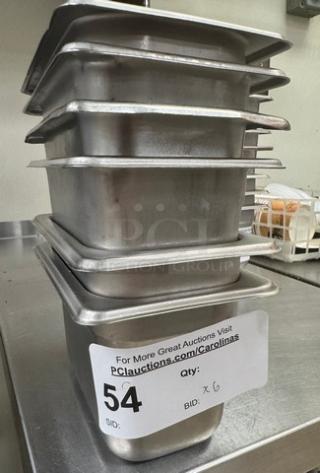 Stack of six 1/6 x 4 stainless steel pans with lids, auction lot number 54, in used condition.