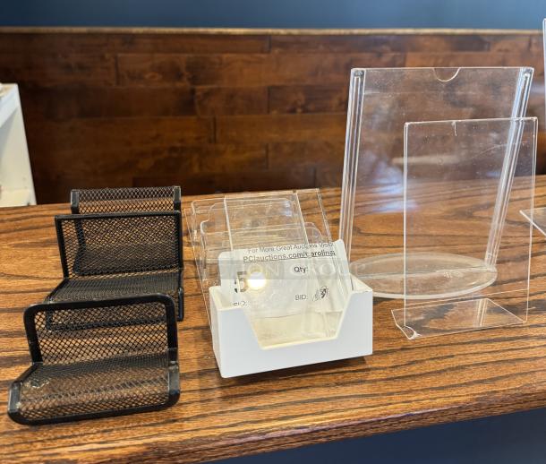 Assorted business card holders on display, including black mesh and clear plastic designs, in good condition.