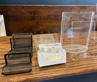 Assorted business card holders on display, including black mesh and clear plastic designs, in good condition.