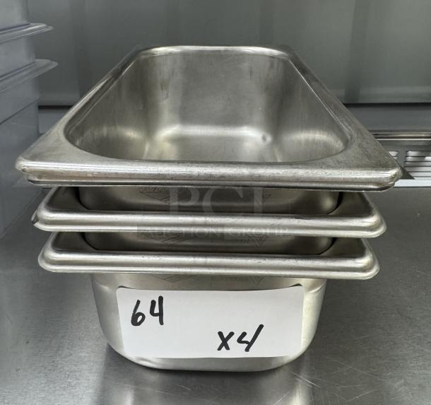 Four stainless steel 1/3 x 4 pans with lids, excellent condition, durability evident. Label reads "64 x4."