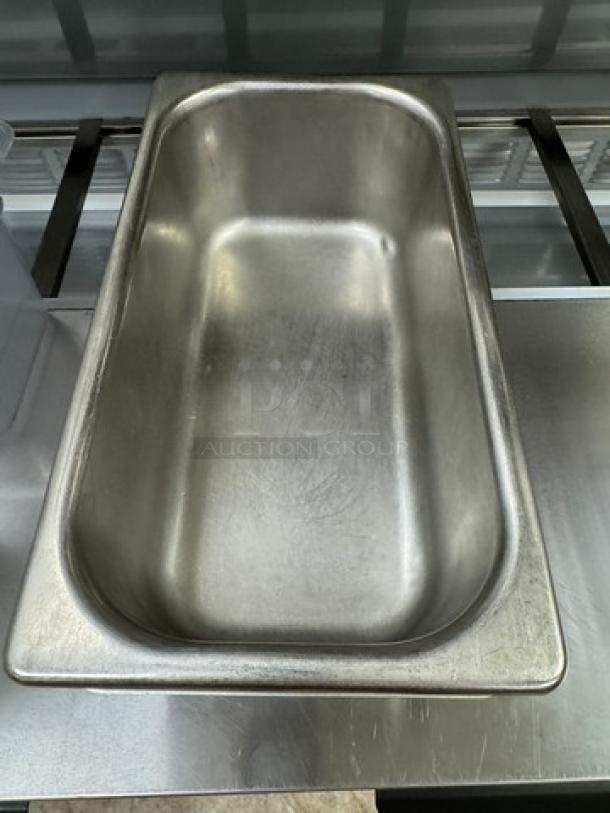 Stainless steel 1/3 x 4 pan with lid, slight wear visible, ideal for restaurant use, 4 units available.