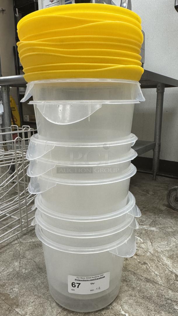 Rubbermaid plastic containers with yellow lids, stack of 8, marked with auction tag "67," in excellent condition.