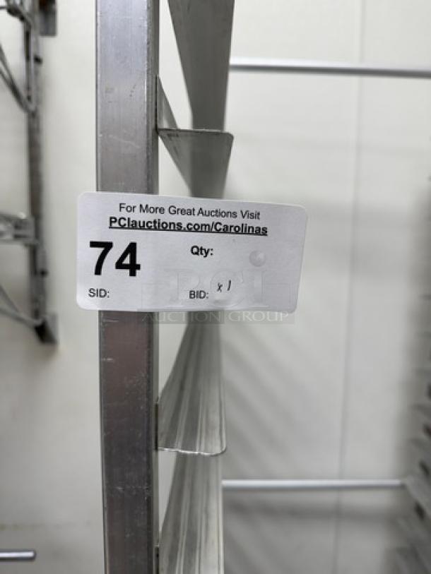 Stainless steel sheet pan rack with multiple slots, auction label showing item number 74.
