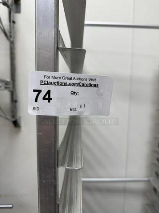 Stainless steel sheet pan rack with multiple slots, auction label showing item number 74.