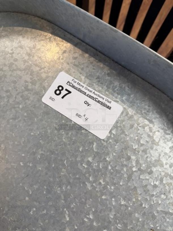 Oval tin tray with a textured surface, labeled "87," part of a set of four decorative display trays.