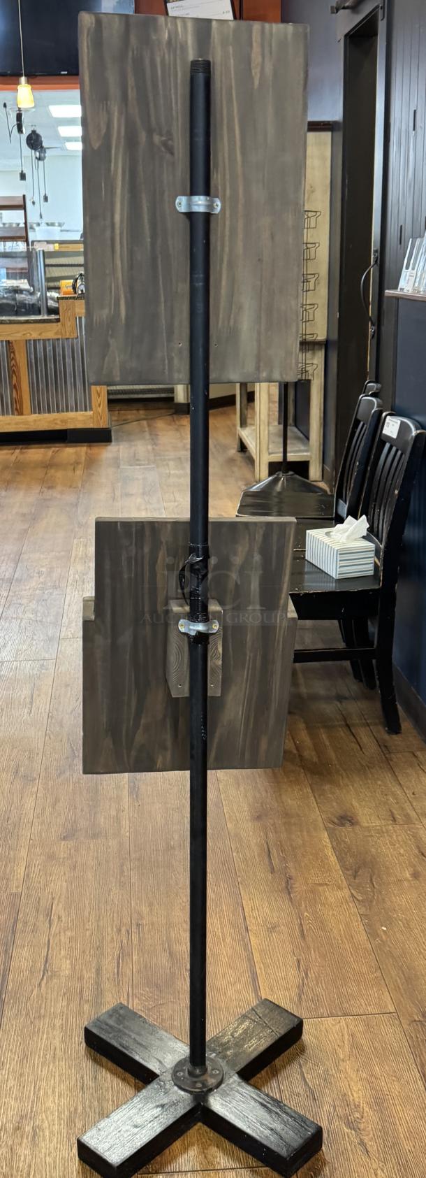 Decorative wooden menu floor sign with two dark wood panels, metal pole, and X-base. Rustic design, ideal for restaurants.