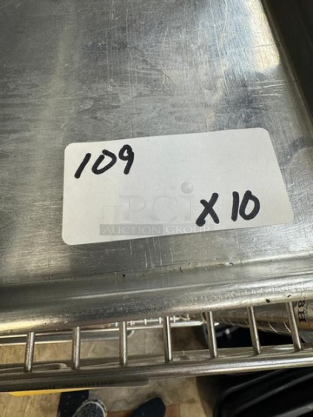 Full size sheet pans stack, set of 10, stainless steel, used condition, auction lot label "109 x10" visible.