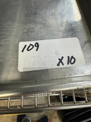 Full size sheet pans stack, set of 10, stainless steel, used condition, auction lot label "109 x10" visible.