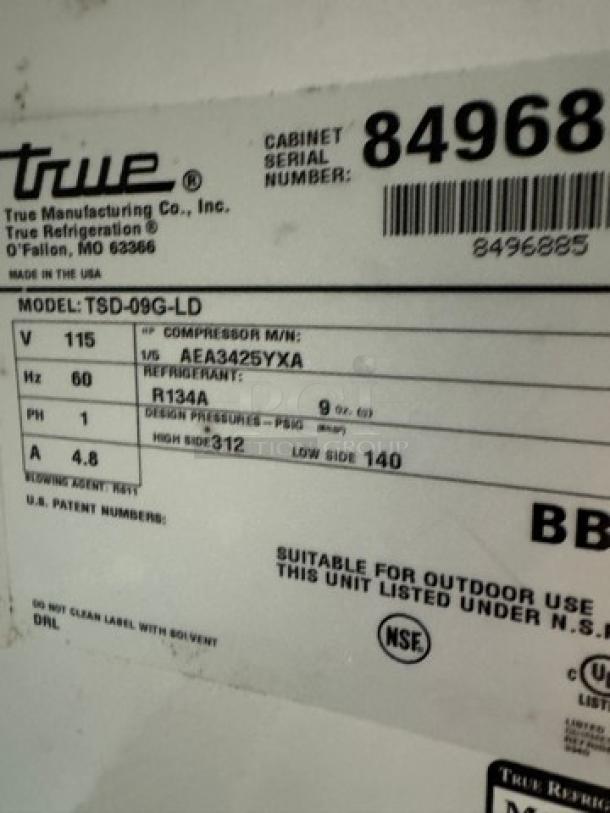 True Refrigerated Display Case, Model TSD-09G-LD, tested and working, features label with specifications and NSF certification.