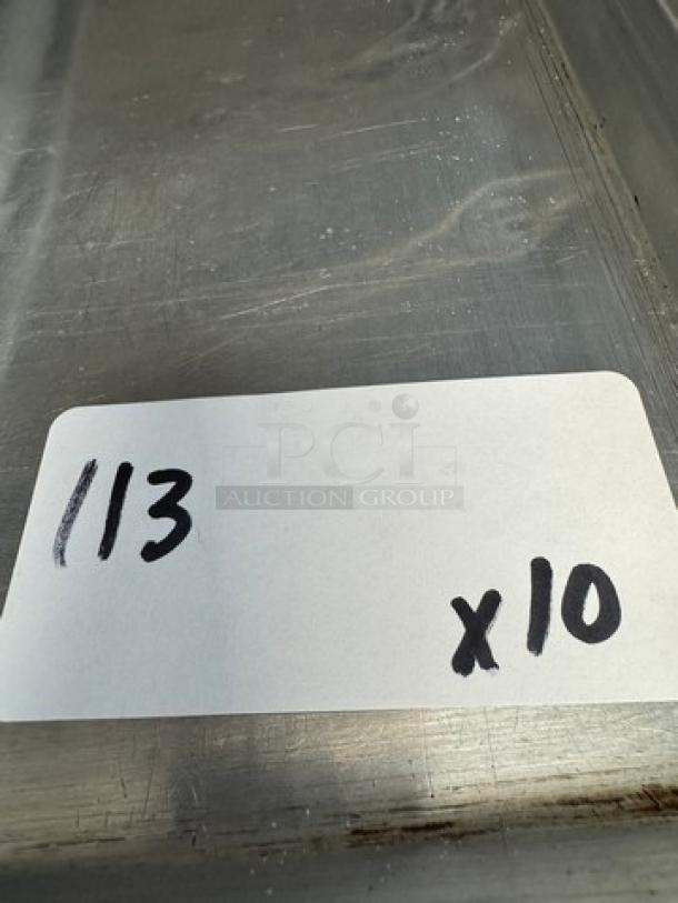 Full-size sheet pans, set of 10, metal surface with visible scratching. Auction tag reads "113 x 10".