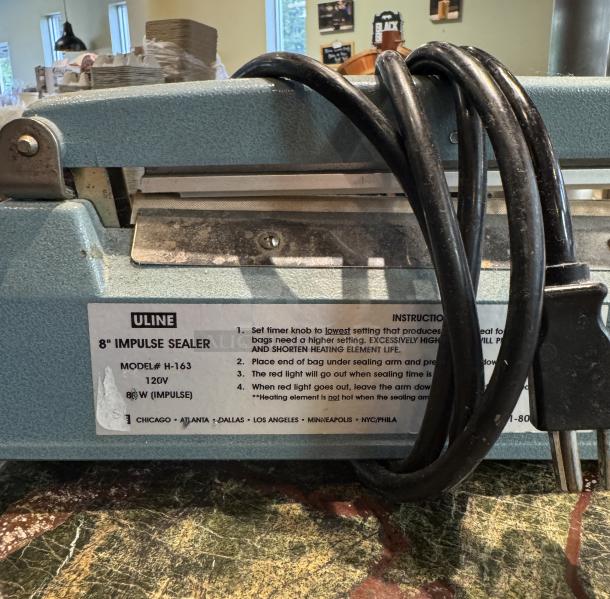 Uline 8" Impulse Sealer, Model H163, 120V 86W, blue casing, attached labeling with instructions, power cord visible.