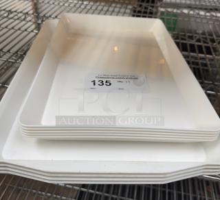 Assorted heavy duty white plastic serving trays, set of 9. Features 9 trays in good condition with auction label 135.