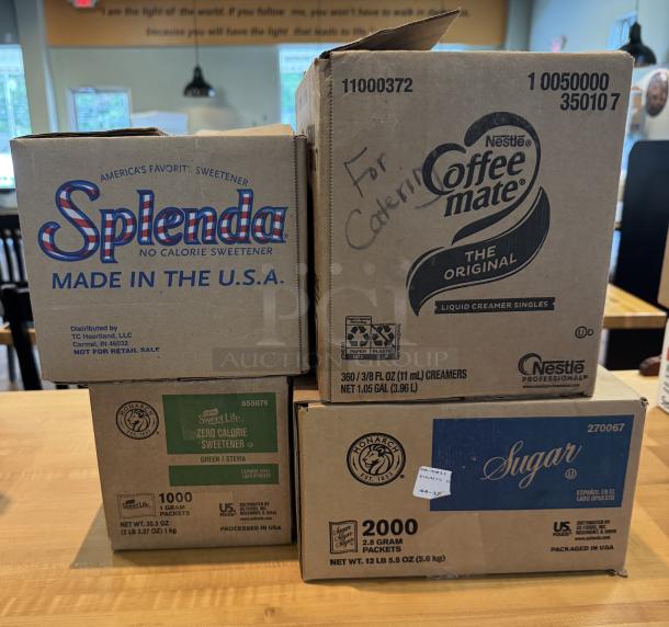 Assorted coffee condiments: Coffee Mate creamer, Splenda sweetener, Monarch sugar packets. Condition: boxed, labeled for catering use.