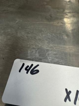 Full size sheet pan stack with a handwritten label "146 x10," indicating a lot of 10 pans. Visible metal surface, minor wear.