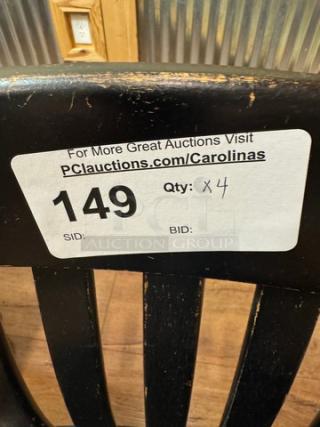 Set of four black dining room chairs with visible wear. Auction tag indicates lot number 149, quantity x4.