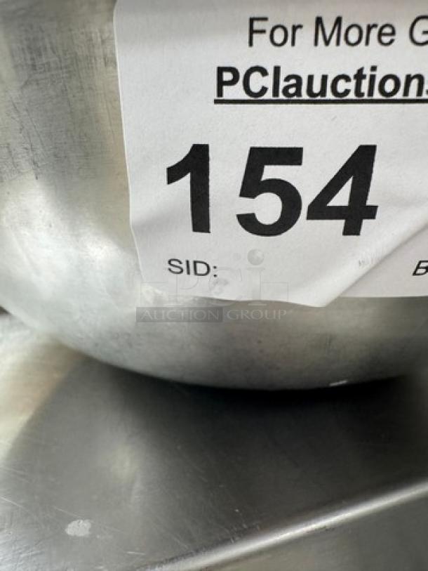 Stainless mixing bowl with auction tag number 154, showing side detail. Part of a set of three.