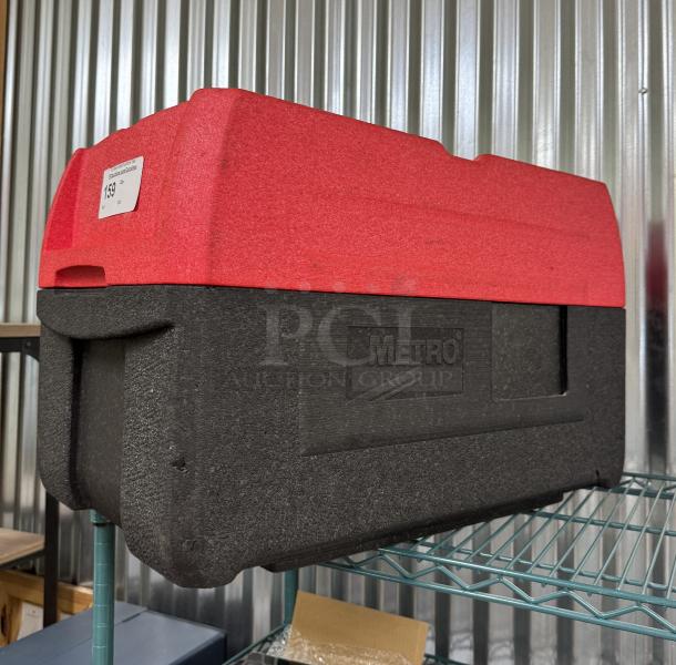 Red and black Portable Metro Cooler in excellent condition, branded with "Metro." Sturdy design, ideal for transport.