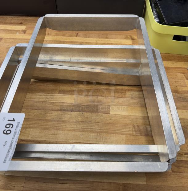 Half size sheet pan extenders, set of 5, metallic finish, minimal wear. Includes auction tag number 169.