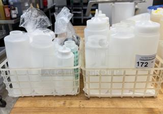 Assorted condiment dispensers and lids in two baskets, various sizes, new condition, auction tag reading "172".