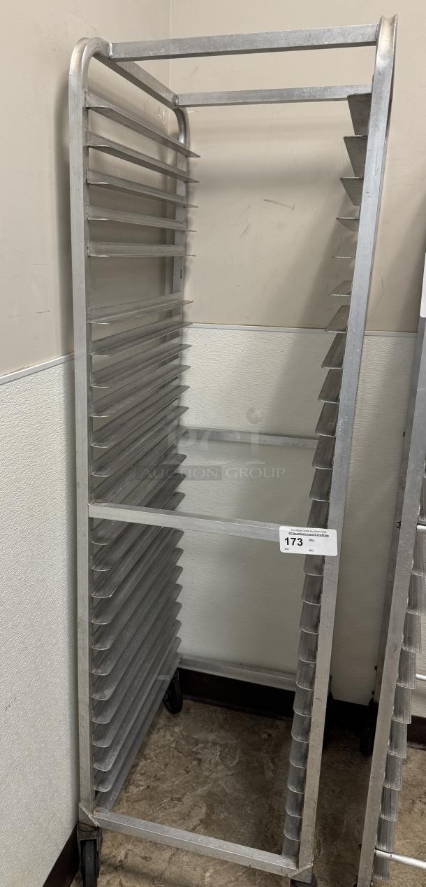 Rolling sheet pan rack with multiple slots, metal construction, used condition. Features wheels for mobility and auction tag 173.
