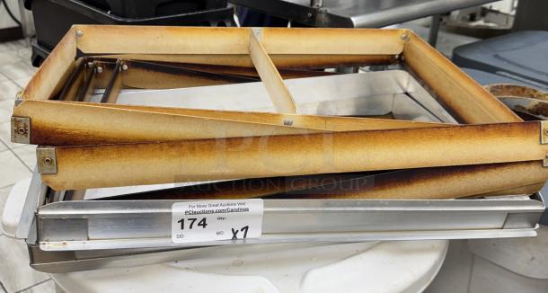 Full-size sheet pan extenders, stacked, showing wear and discoloration. Auction tag reads "174, BID x1."