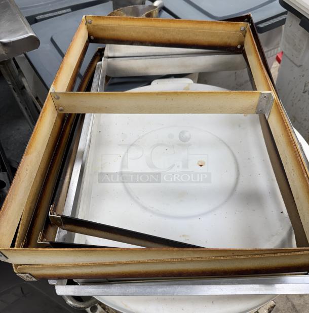 Full-size sheet pan extenders, stack of 7. Show signs of use with visible browning on edges. Suitable for commercial baking.