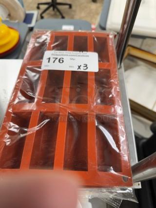 Red silicone baking molds, 3-pack, new in packaging. Rectangular shape with six cavities each. Auction label reads "176 Qty x3".