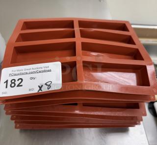 Red silicone baking molds stack, set of 8, with rectangular cavities. Auction tag reads "182, Qty: 8".