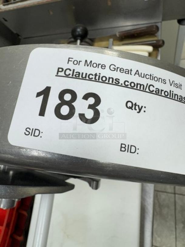 Nemco slicer with attached cutting board, showing auction tag number 183. Appears in used condition.