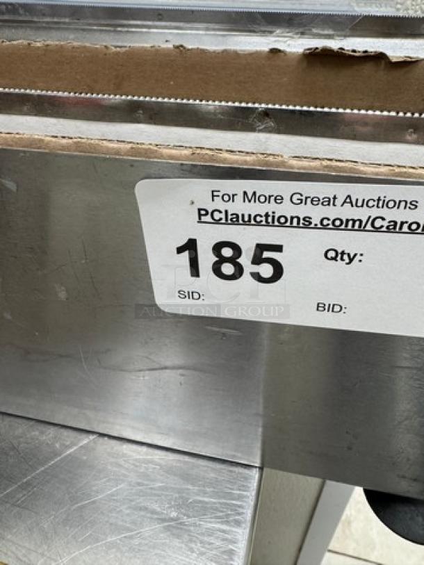 Metal and cardboard plastic wrap holder with cutting edge, showing auction label number 185, for holding and cutting plastic wrap.
