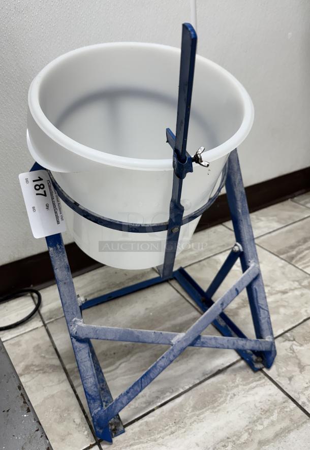 Holder/Tilt stand for 5-gal bucket, blue metal frame, adjustable clamp, tag with bidding number 187 visible, used condition.