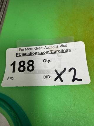 Two green plastic cutting boards with visible auction tag marked "188" and "Bid x2". Slight discoloration noted.