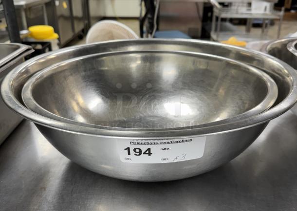 Stainless steel mixing bowls, set of three, in good condition with auction label showing lot number 194.