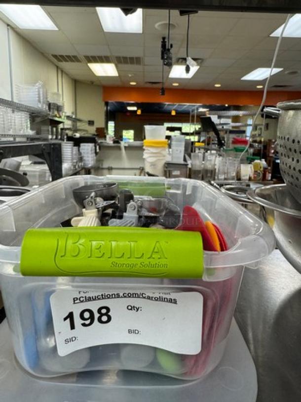 Clear container with assorted baking utensils, "Bella" branded, auction tag "198" visible, good condition.