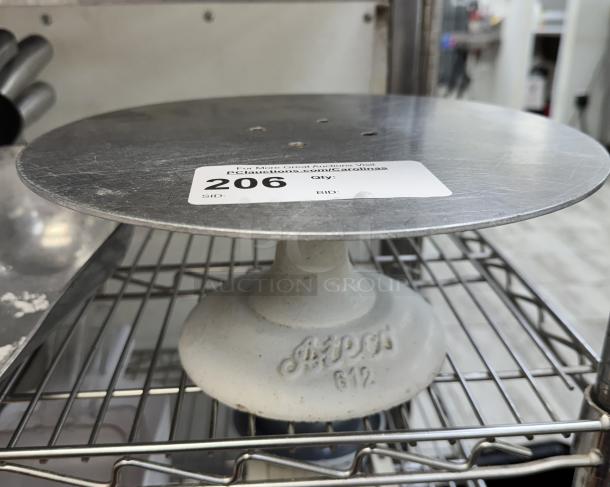 Cake stand with cast iron base, fair condition, model "APT CO 612," auction label "206" on top, wire rack shelf.