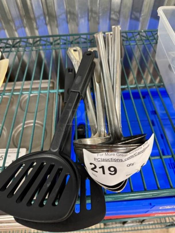 Set of 9 kitchen utensils including ladles and spatulas. Contains stainless steel and black plastic items in good condition. Lot tag marked "219".