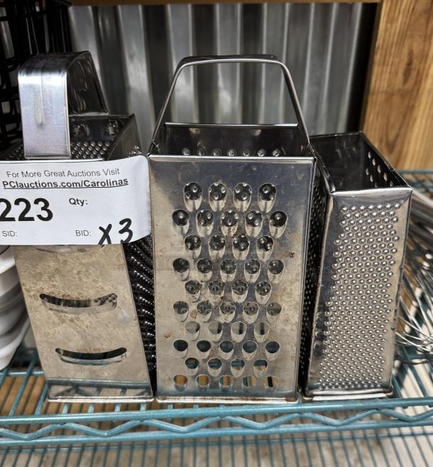 Three metal box graters with varying hole sizes, used condition, numbered tag indicating item 223, bid quantity of 3.