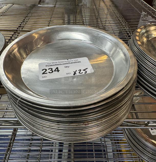 Metal pie pans, lot of 25, stacked on a wire shelf, good condition. Auction label shows item number 234, bid x25.