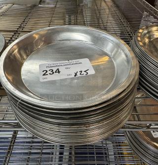 Metal pie pans, lot of 25, stacked on a wire shelf, good condition. Auction label shows item number 234, bid x25.