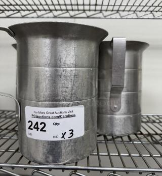 Metal measuring cups, set of 3, well-used condition on wire rack. Auction tag: Lot 242, bid x3.