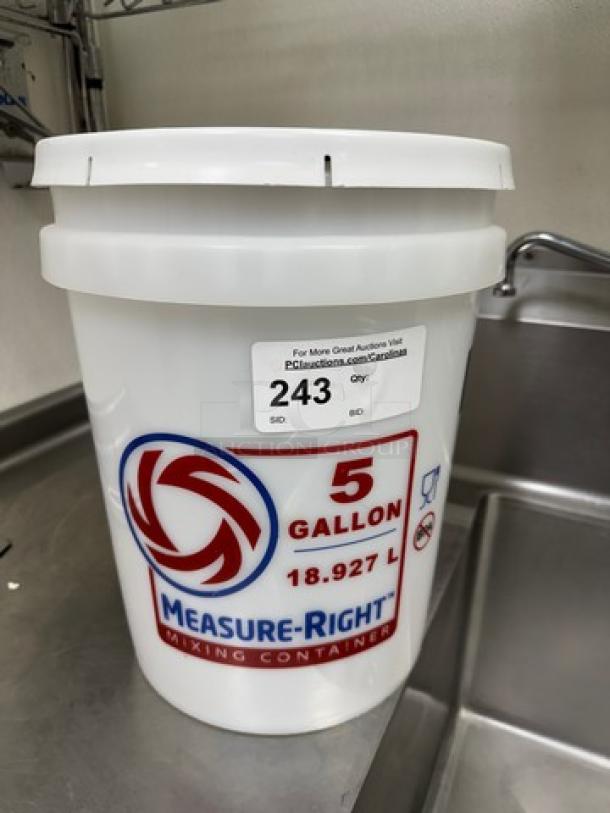 Measure-Right 5 Gal. mixing container with lid, marked 18.927 L. Features branding label, auction tag with lot number 243.