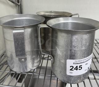 Three metal 2 Qt. measuring cups with handles, slightly worn. Auction tag reads "245" with website details.