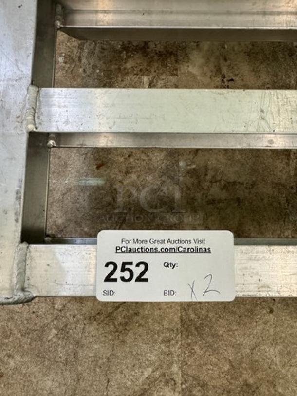 Aluminum dunnage rack showing visible auction tag with lot number 252 and bid quantity x2; in used condition.