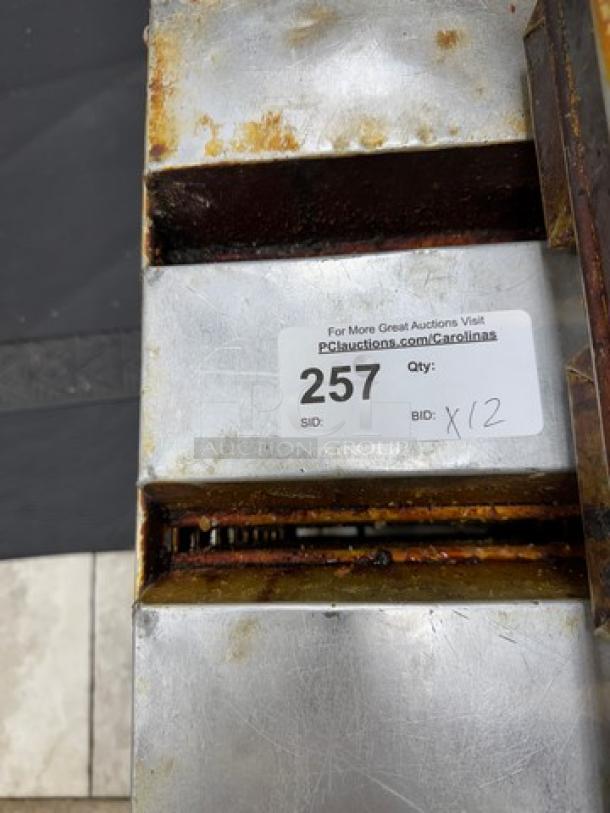 Set of 12 used metal bread pans with rust and wear. Auction label reads "257, Qty: 12." Ideal for bakery use.