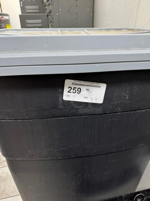 Large trash can, black plastic, grey lid, auction lot label "259". Signs of wear. 4 available for bid.