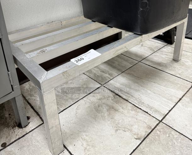 Metal dunnage rack with slatted top, in used condition. Auction label indicates item number 260.