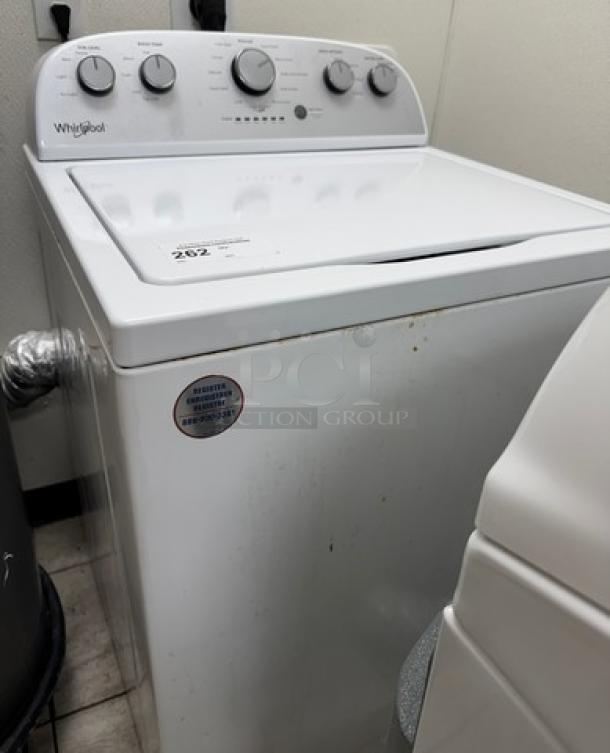 Whirlpool clothes washer with top controls, white finish, good condition, minor scuffs, energy guide label and settings visible.