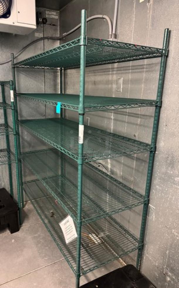 Green wire rack with 5 shelves, metal construction, sturdy frame. Slight wear visible. No brand or model markings visible.