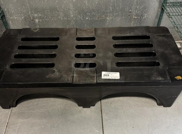 Black dunnage rack with slotted top, in used condition. Label numbered 269 is attached. Durable plastic construction.